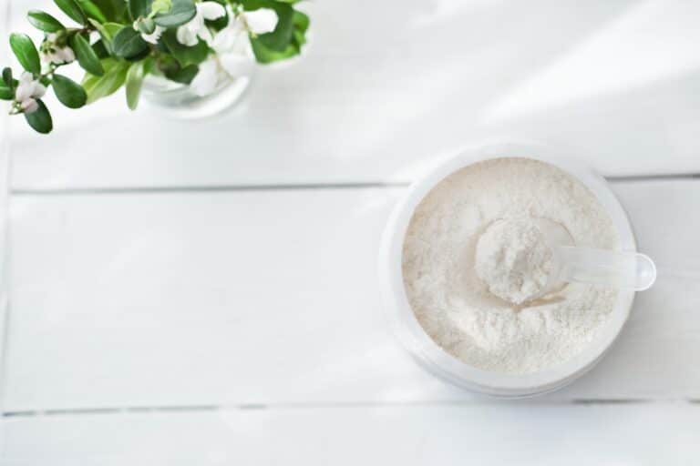 Collagen or protein in powder on white wooden table
